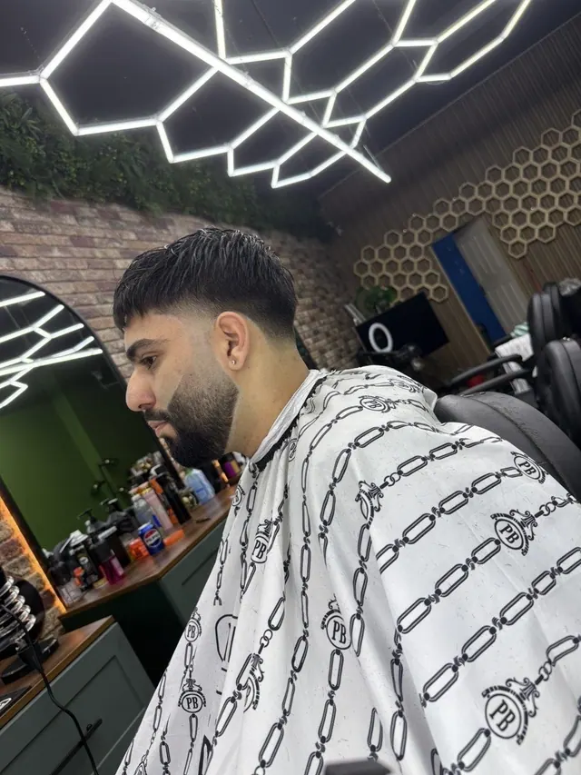 In the chair at The Rock Barbers, with the hex lights behind
